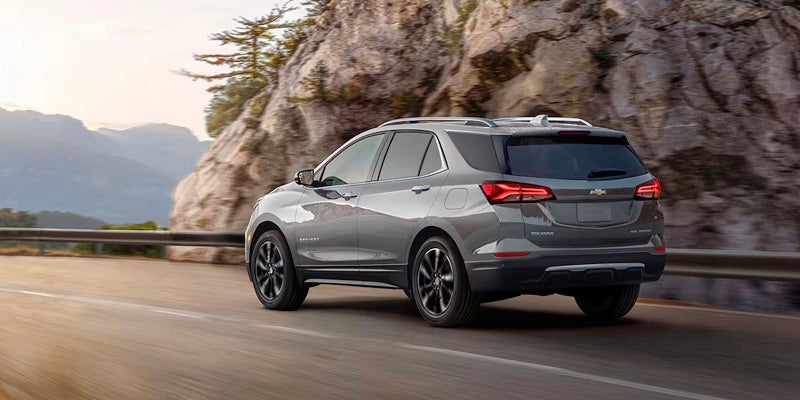 Grey Chevrolet Equinox driving beside mountain road